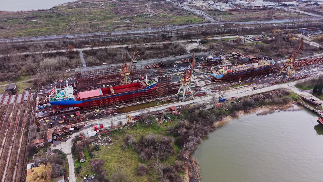 Porto trafficato con molteplici navi in costruzione e riparazione.