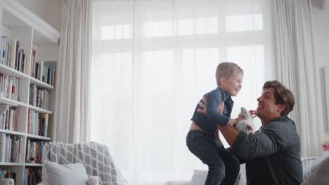 little-boy-jumping-into-fathers-arms-happy-dad-gently-catching-his-son-enjoying-playful-game-with-child-at-home-4k