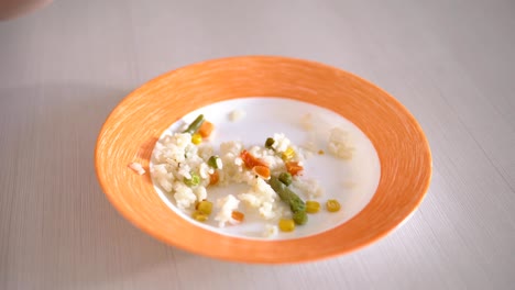 arroz con verduras en un tazón con franjas de naranja