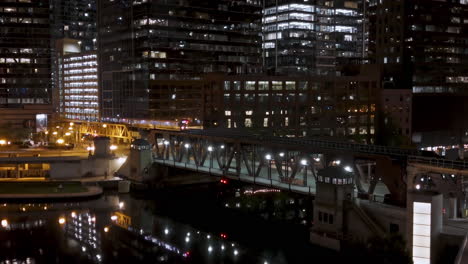 Train-moving-over-the-illuminated-Lake-Street-Bridge,-night-in-Chicago,-USA