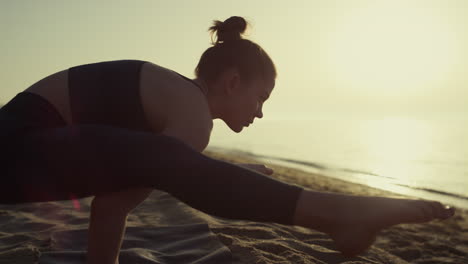 proffesional yoga woman leaning on hands firefly position at sunset close up.