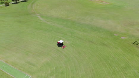 tractor mowing grass on a sports field