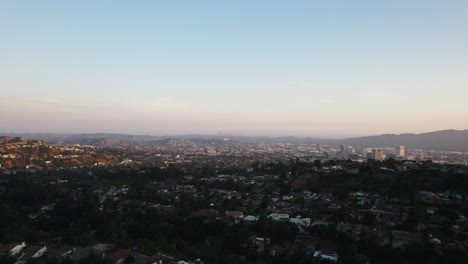 forwards fly above residential suburb of metropolis at golden hour