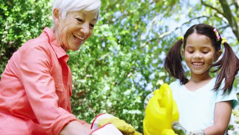 grandmother and grand daughter watering plants