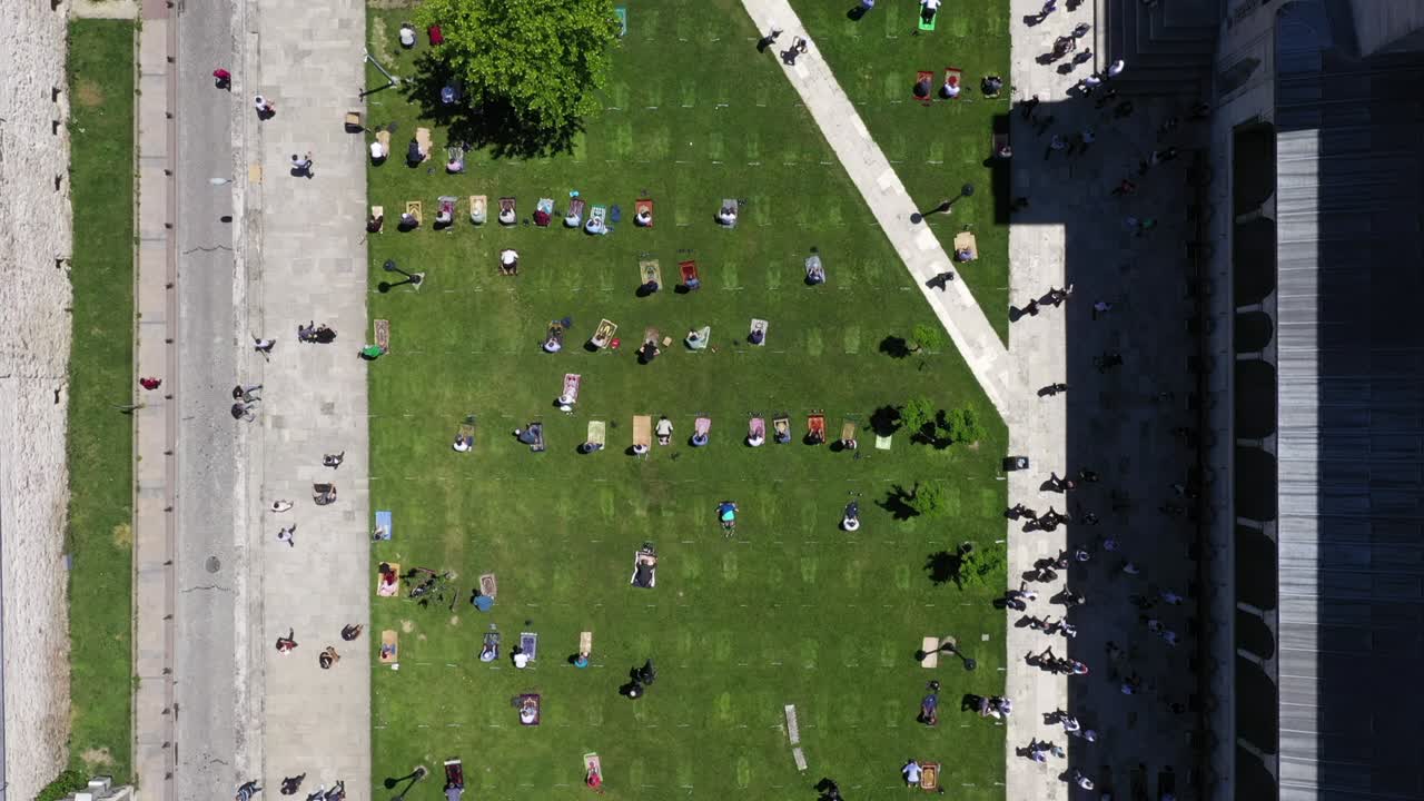 personas que rezan a distancia social en el jardín de la mezquita durante el período de coronavirus