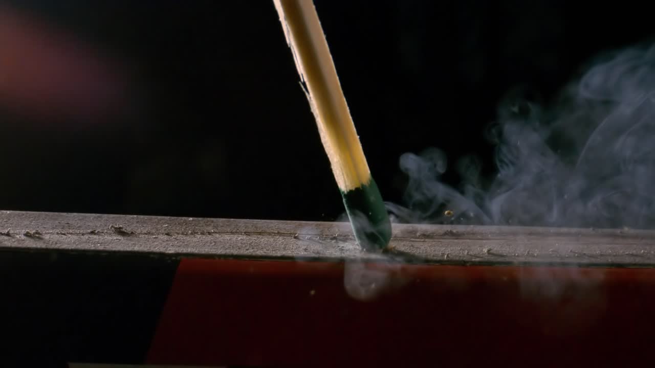 un primer plano de cerilla ardiente en un fondo oscuro, filmado con una cámara súper lenta de 1000 fotogramas por segundo.