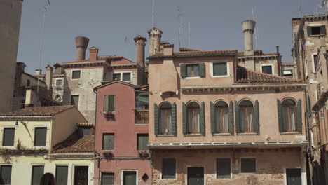 Bunte-Fassade-Eines-Gebäudes-Mit-Schönen-Grünen-Fenstern-Und-Einzigartigen-Schornsteinen,-Venedig,-Italien