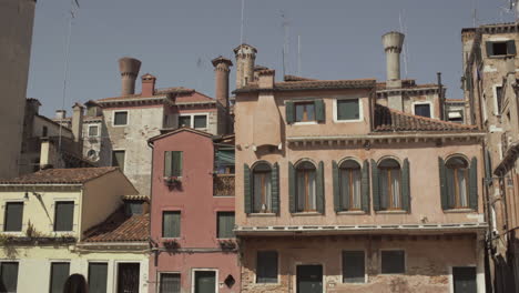 Colorful-Facade-of-a-building-with-beautiful-green-windows-and-unique-chimneys,-Venice,-Italy