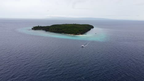 Vista-Aérea-De-La-Isla-Sumilon,-Con-Un-Barco-Turístico-Filipino-Banca-Pasando,-Una-Pequeña-Isla-En-Mar-Abierto-Con-Una-Playa-De-Arena-Blanca-Frente-A-La-Costa-De-Oslob-En-Cebu,-Filipinas