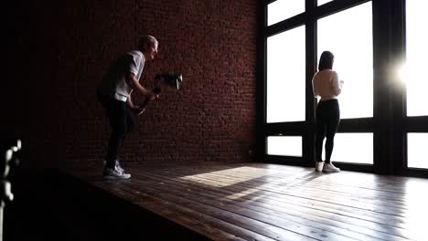 sesión de producción de video independiente, puesto de modelo cerca de una ventana brillante del estudio