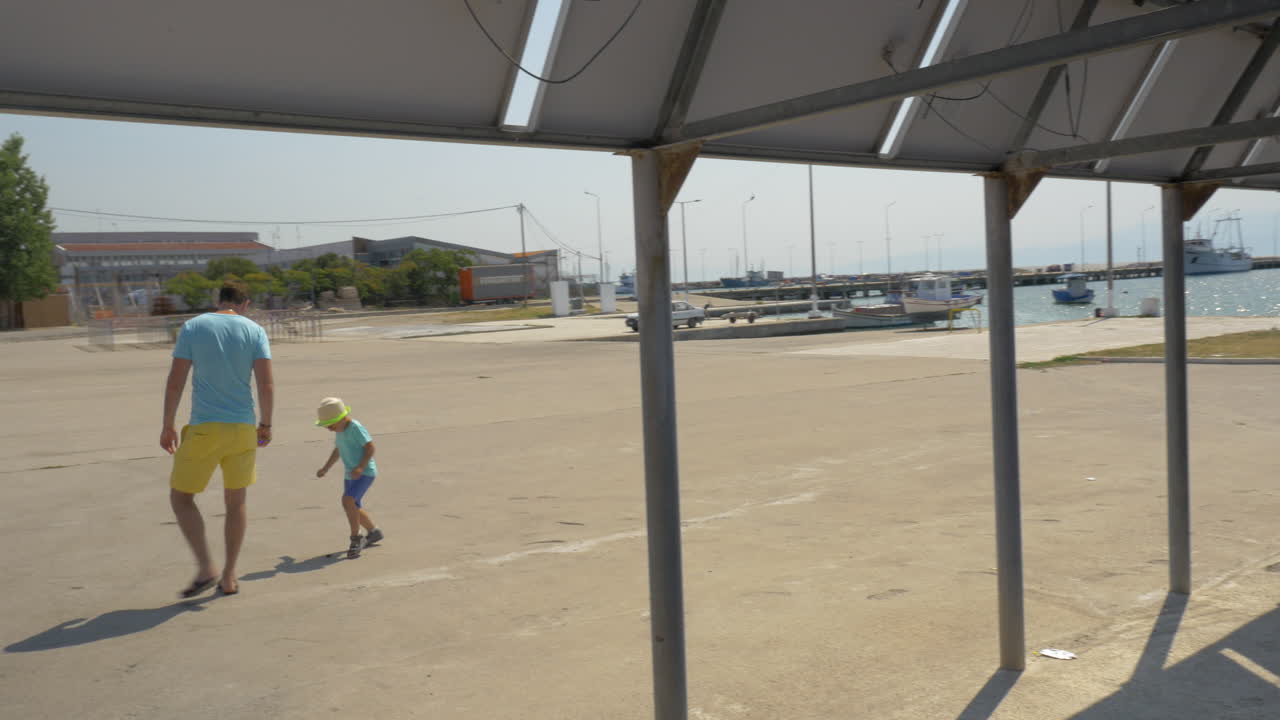 Father and son playing with bottle cap outdoor