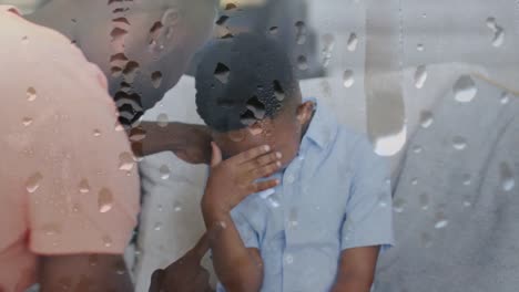 animación de gotas de lluvia sobre padre afroamericano gritando a su hijo llorando