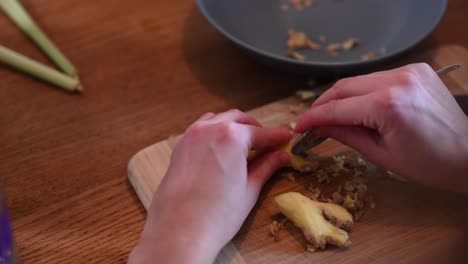 A-stationary-footage-of-a-woman's-hands-while-peeling-off-the-skin-of-the-ginger-using-a-spoon