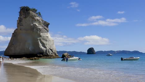 wide slow panning shot of te hoho rock and cathedral cove beach