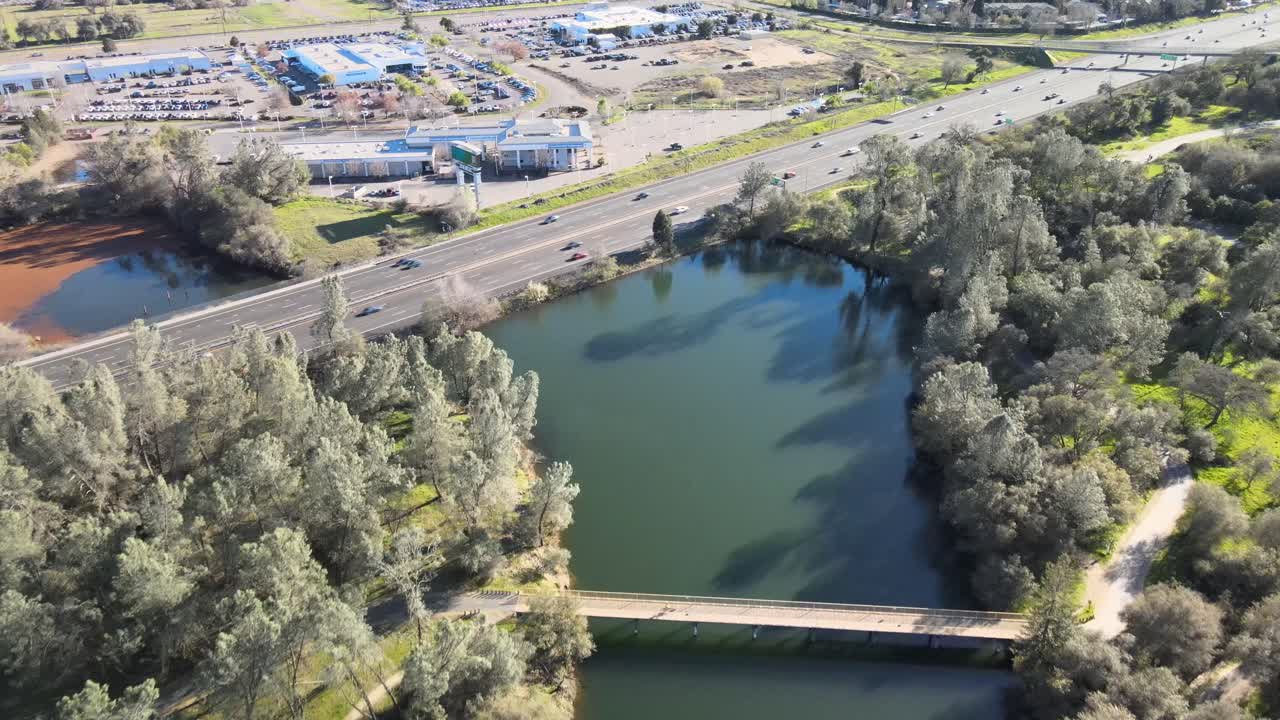 volando sobre la autopista lincoln y el puente del rastro conmemorativo de jedediah smith en el lago natoma cerca de folsom, california