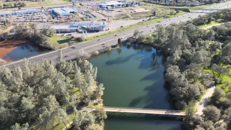 Volando-Sobre-La-Autopista-Lincoln-Y-El-Puente-Del-Rastro-Conmemorativo-De-Jedediah-Smith-En-El-Lago-Natoma-Cerca-De-Folsom,-California