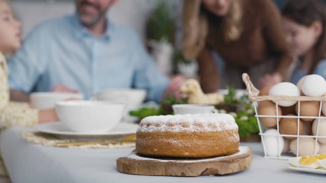 Detail of easter cake on the table and people in the background.