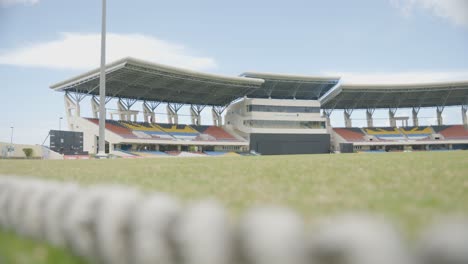 rack focus from the boundary rope at cricket ground, viv richards stadium in antigua to reveal the stands