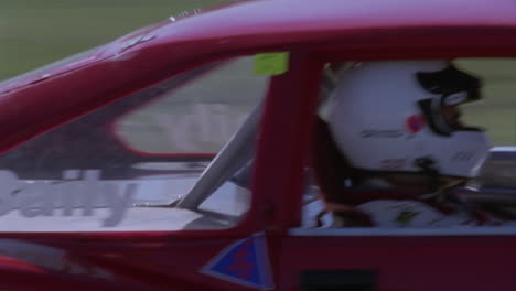 two cars race down a track and prepare to go into a sharp turn