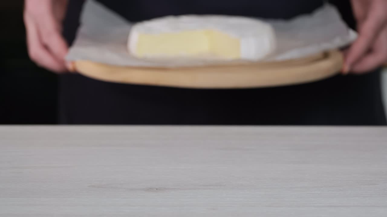 camembert queso crema de primer plano. el chef pone en la mesa con delicioso queso suave camembert. cabeza de queso de leche de cabra con moho blanco. cabeza redonda camembert cortado en pedazos. concepto de producto lácteo