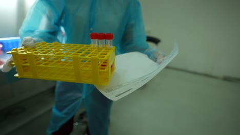un trabajador de la salud que transfiere viales que contienen muestras de virus a cámara lenta 4k