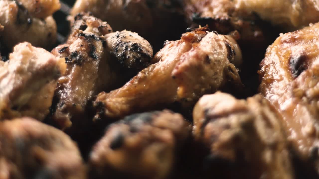 숯불 그릴에서 나오는 닭 날개와 연기의 슬로우 모션 클로즈업 샷