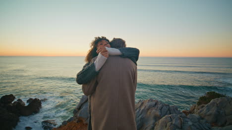 tanned girl embracing boyfriend at sunset marine horizon closeup. pair cuddling