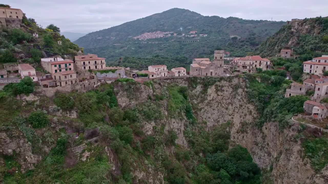 Storico villaggio sulla scogliera in un paesaggio montuoso