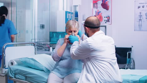 el médico pone una máscara de oxígeno.