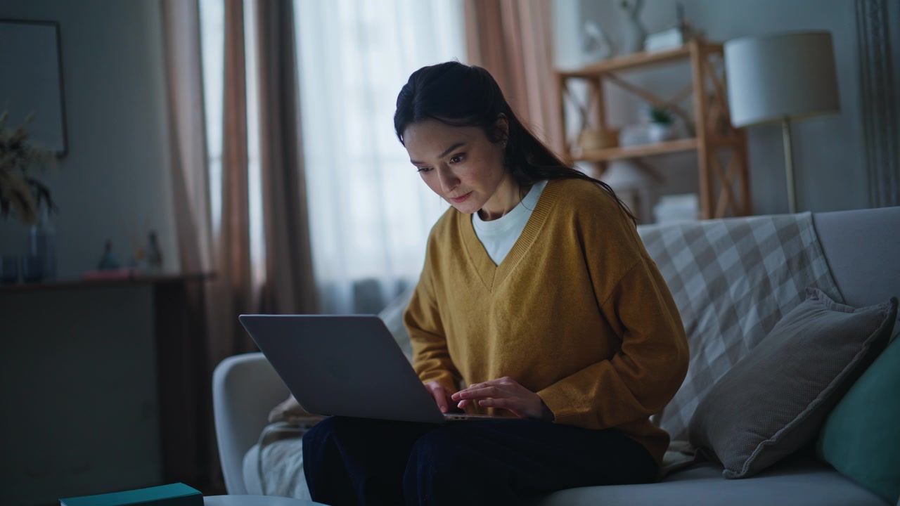Serious woman browsing laptop sitting evening home closeup. Stressed brunette