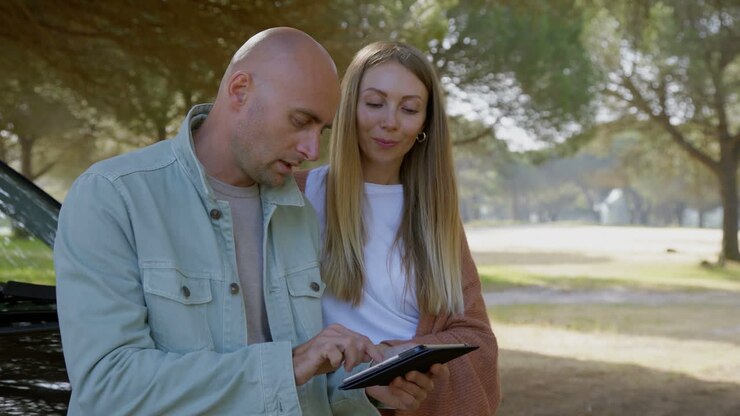 Couple discussing route on digital tablet