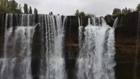 aerial pan right shot of top of natural waterfall