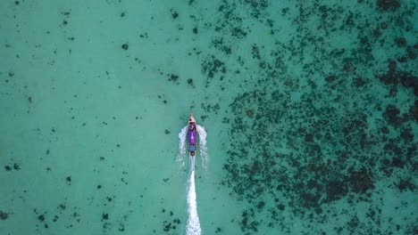 vista de 4k desde arriba, vista aérea impresionante de un bote tradicional de cola larga que navega en un hermoso mar turquesa y claro, islas phi phi, tailandia