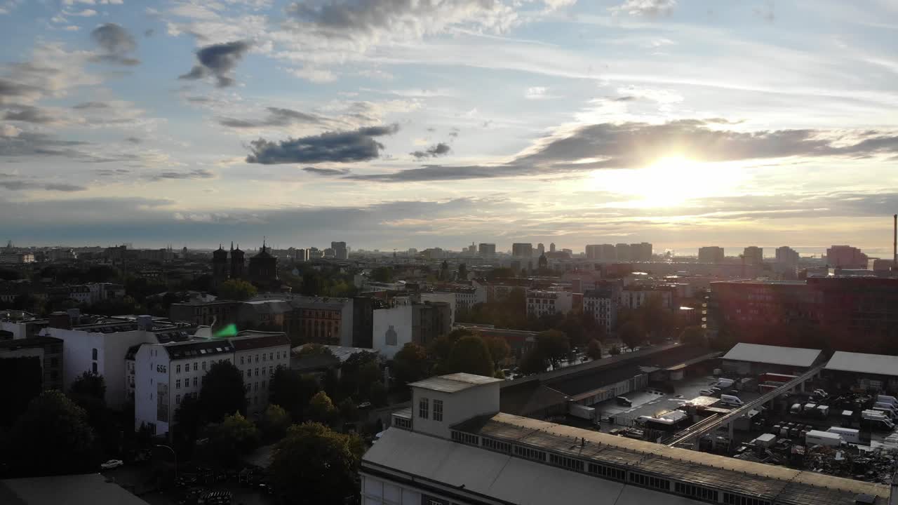 lente de drone 4k flare horizonte do pôr-do-sol se movendo para cima e para os lados no centro da cidade de berlin sobre edifícios de escritórios apartamentos e lojas no verão