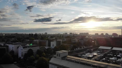 lentes de drones 4k flare horizonte del atardecer moviéndose hacia arriba y hacia los lados en el centro de la ciudad de berlín sobre edificios de oficinas apartamentos y tiendas en el verano