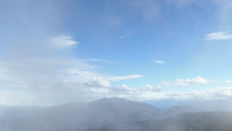 drone pasando a través de las nubes en el cielo azul sobre la meseta verde de prat d&#39;albis, pirineos en francia