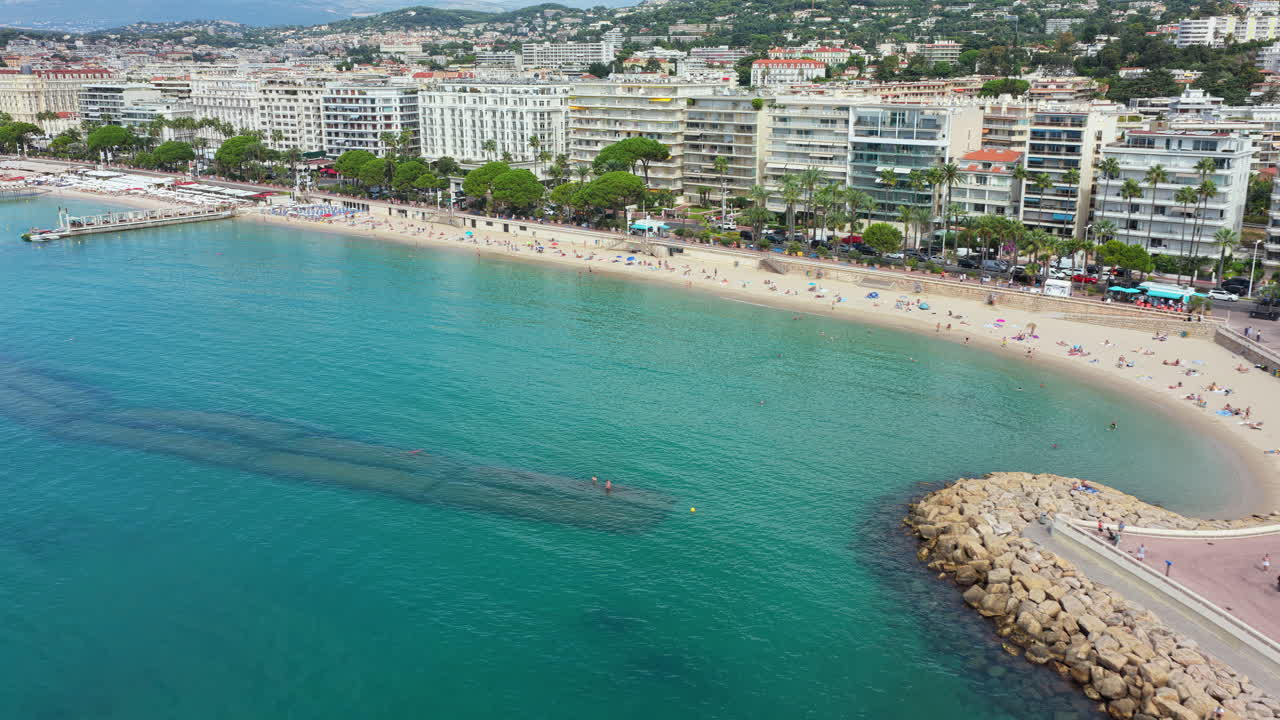 Vista aerea da drone della spiaggia sabbiosa con acqua turchese e costa curva, Cannes, Francia