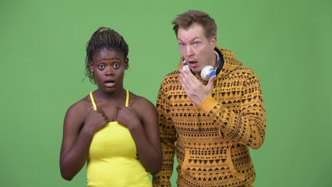 young multi-ethnic couple looking shocked together