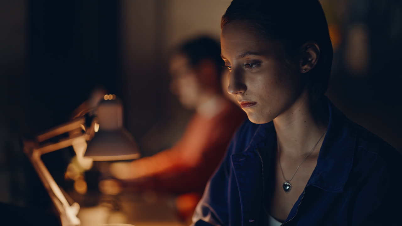 Focused entrepreneurs overtime work in dark coworking closeup. Two programmers