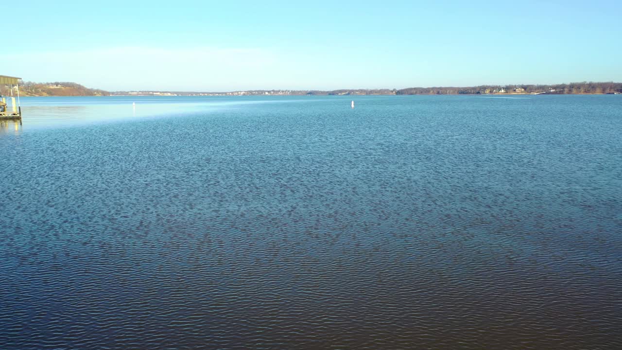 아름다운 맑고 푸른 물에 바람의 잔물결이 있는 미주리 중서부의 테이블 록 호수에 있는 작은 만이나 강 수로에서 보트 탐색을 위한 두 개의 웨이크 부표를 볼 수 있습니다.