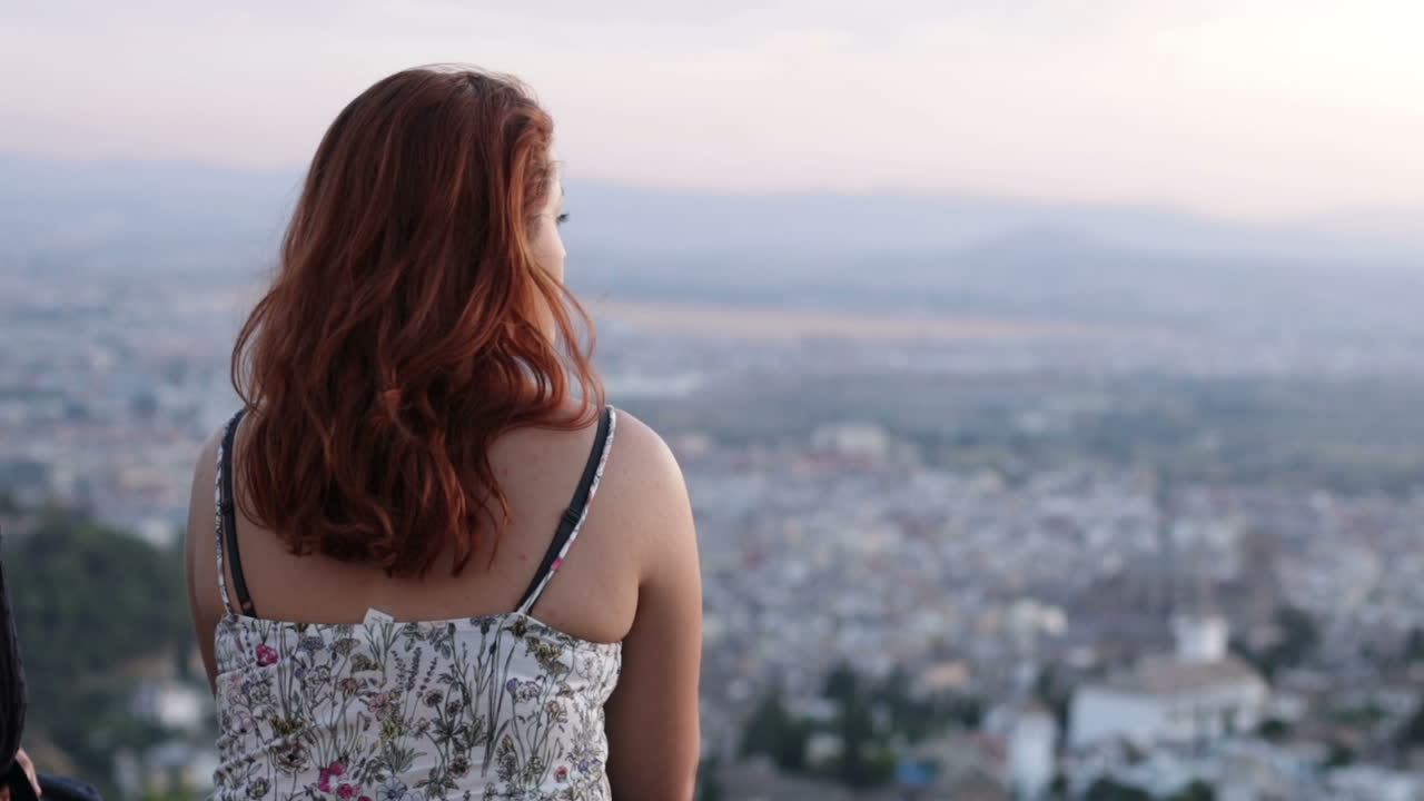 Woman with Red Hair Overlooking City View