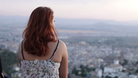 woman with red hair overlooking city view
