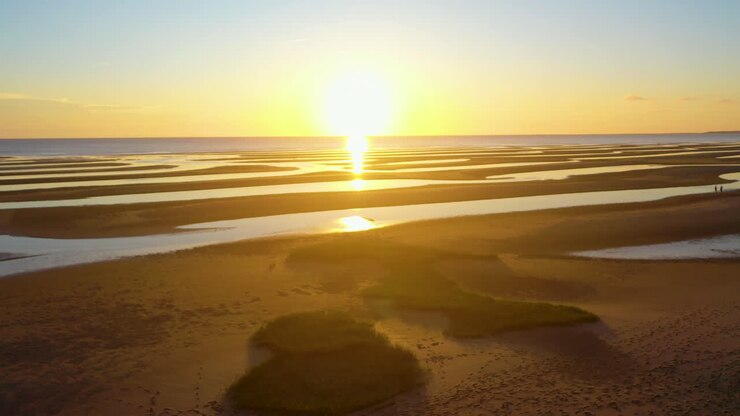Cape Cod Bay Beach Aerial Drone Footage at Low Tide During Golden Hour, Bright Sun Low and Setting, Pan Right