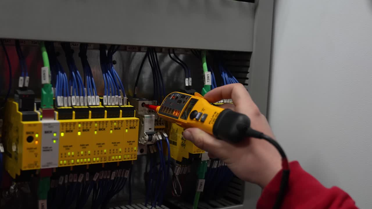 Close-up test on wiring control cabinet and yellow safety modules inside an electrical control panel