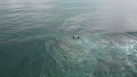 Top-Luftbild-Surfer,-Der-In-Einer-Reihe-Mit-Drohnenaufnahmen-Auf-Wellen-Wartet