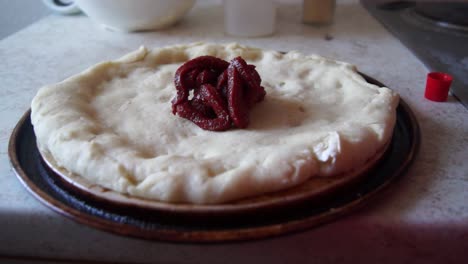 Tomatensauce-Auf-Eine-Vorgebackene-Pizza-Geben