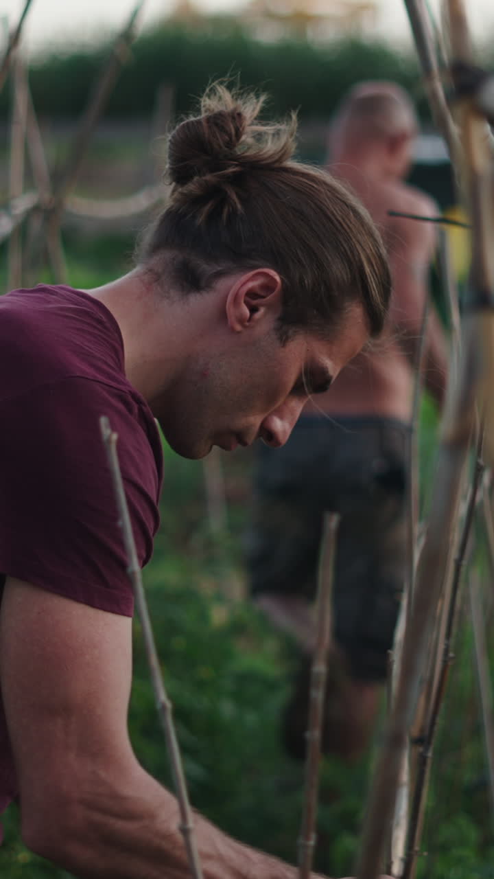 Uomo con chignon che lavora in un giardino verde