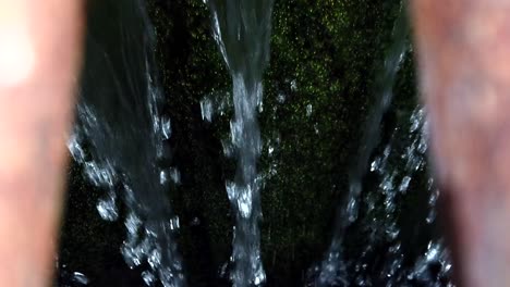 water is seen pouring down a metal grate the surface below it