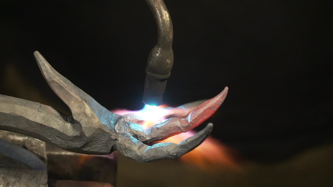 Blacksmith timelapse of heating and bending metal fingers to make a claw