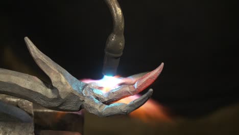 timelapse del herrero de calentar y doblar los dedos de metal para hacer una garra